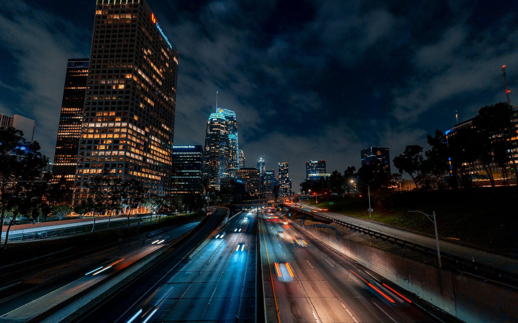 Downtown Los Angeles at night with freeway light trails in the foreground